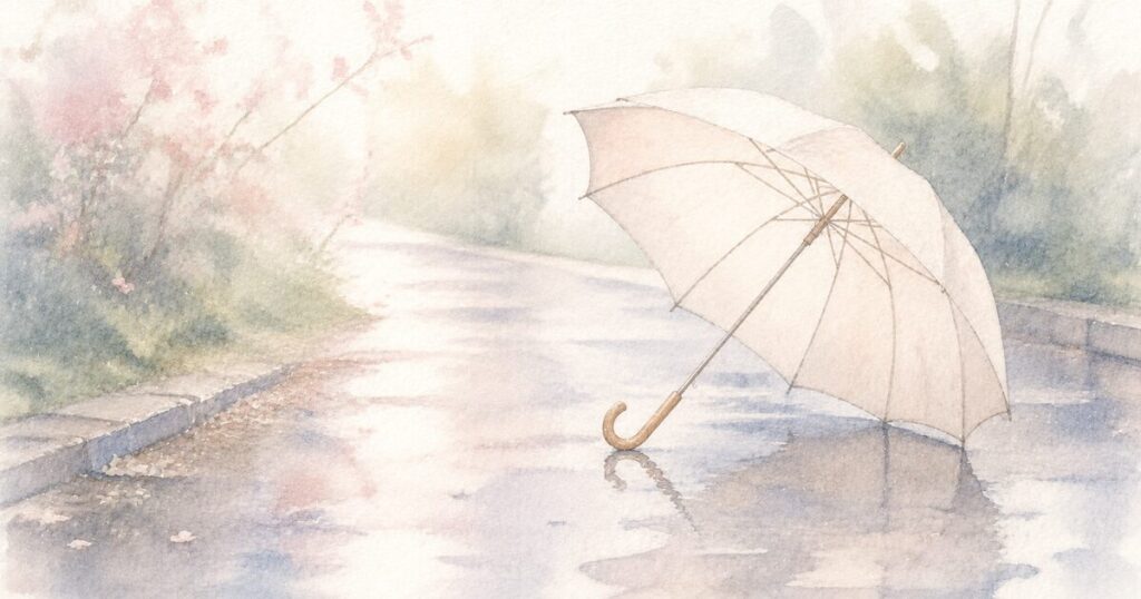 小雨の後の静かな道に置かれた一本の傘と、水たまりに映る柔らかな光の水彩イラスト